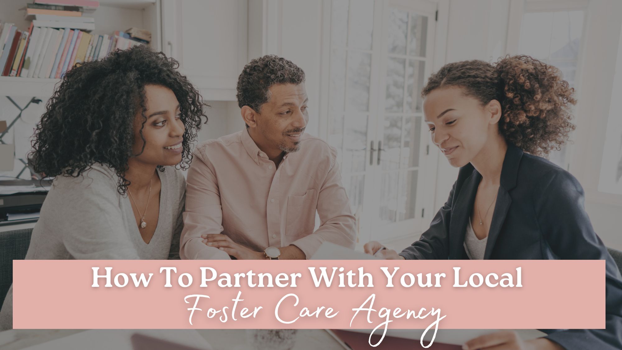 A couple sits down with a worker at a local foster care agency, listening and understanding how to help support that agency.