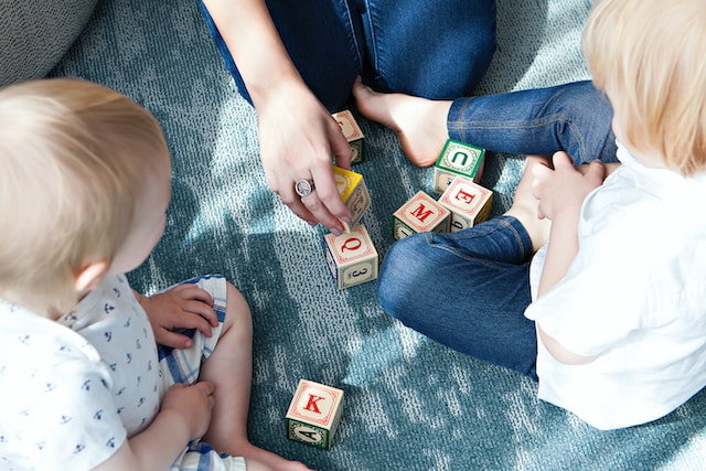 Mom and her two young children playing with blocks
