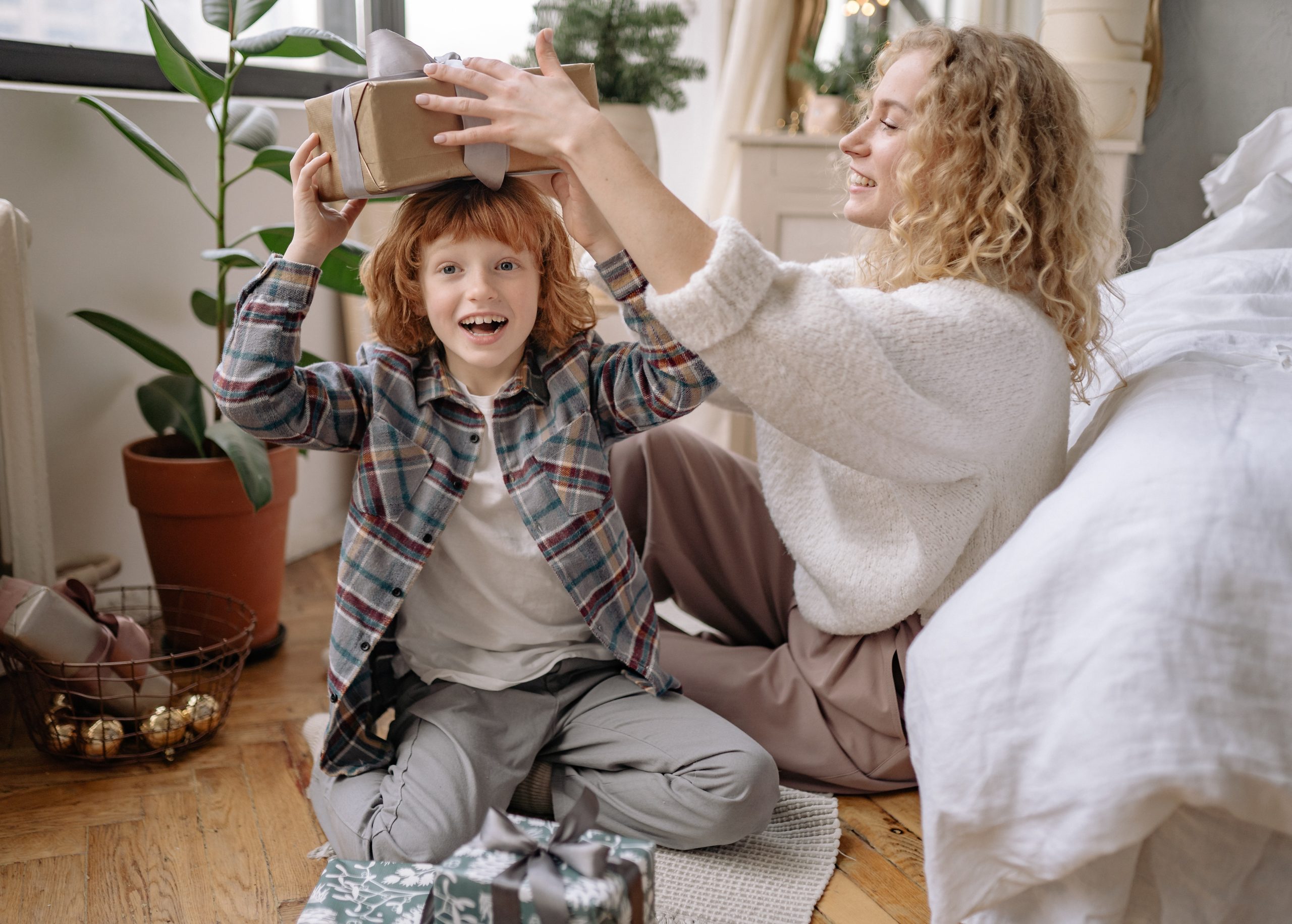 Mom playfully setting a gift on top of her child's head