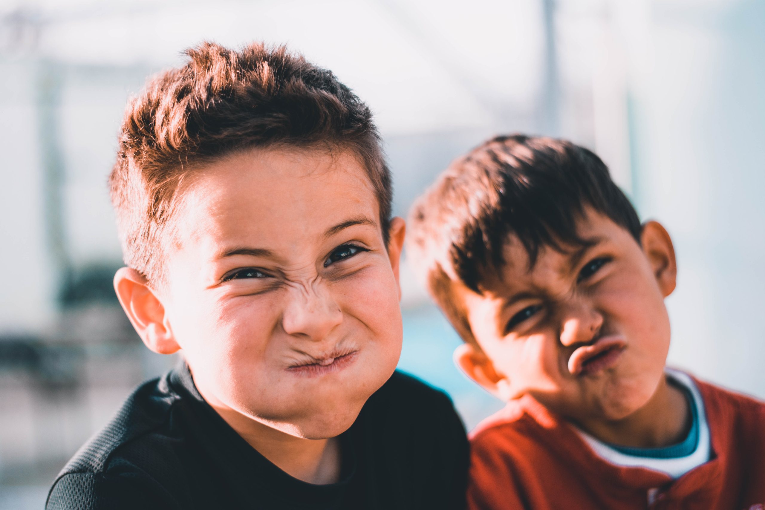 Two boys playfully scrunching their faces for the camera