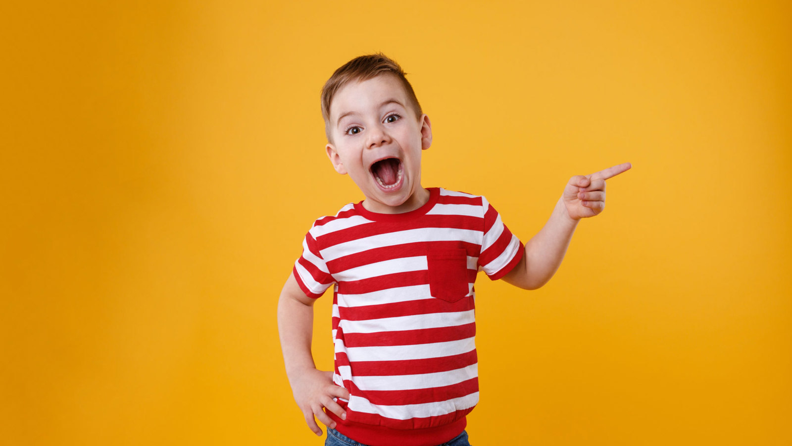 Young boy smiles and points