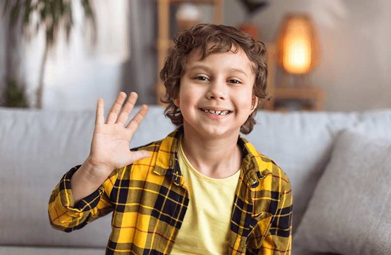 Smiling boy waving at camera
